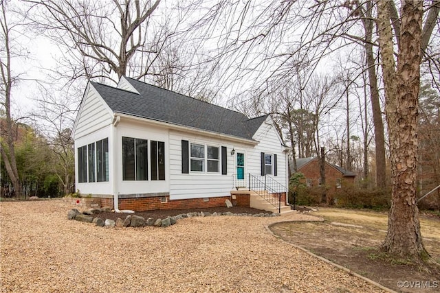 view of front of house featuring crawl space, a sunroom, and a shingled roof