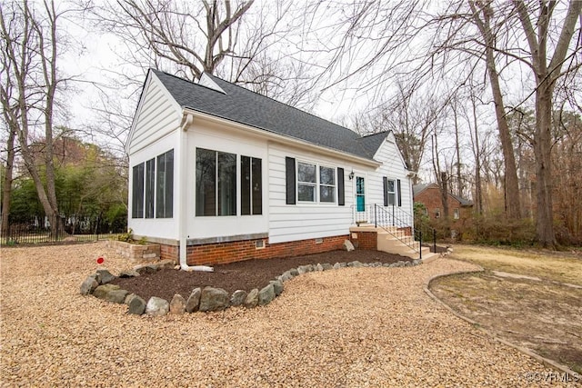 view of front of home featuring crawl space, roof with shingles, and a sunroom