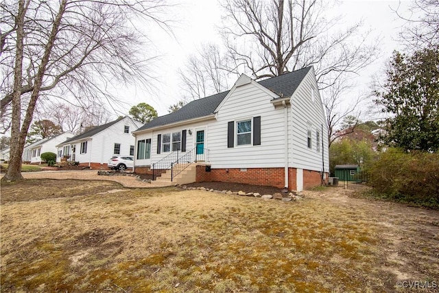 view of front facade with a shingled roof and crawl space