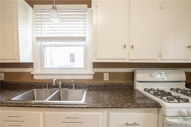 kitchen with a sink, decorative light fixtures, white range with gas stovetop, and white cabinets