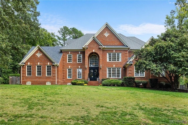 view of front of house featuring brick siding, central AC unit, and a front yard