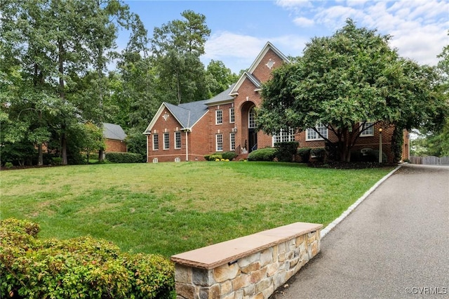 view of front of home featuring a front yard and brick siding