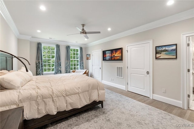 bedroom featuring visible vents, crown molding, and light wood-style flooring