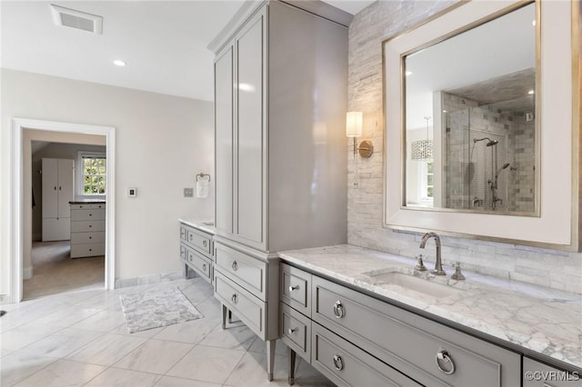 bathroom featuring visible vents, a stall shower, vanity, and decorative backsplash