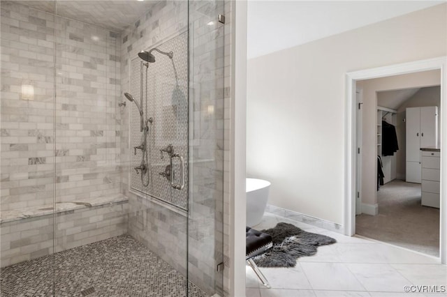 full bathroom featuring a freestanding tub, a shower stall, and baseboards