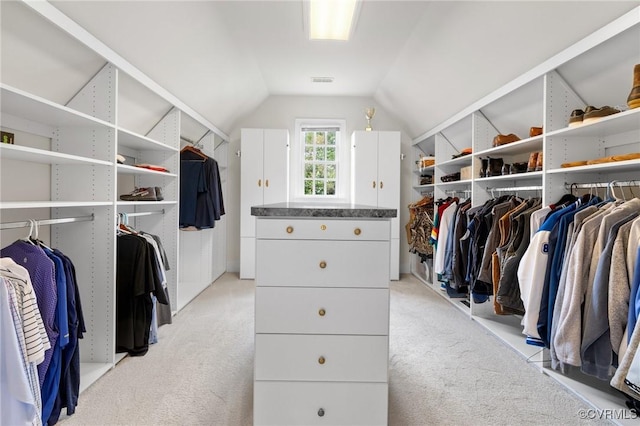 spacious closet with lofted ceiling, light carpet, and visible vents