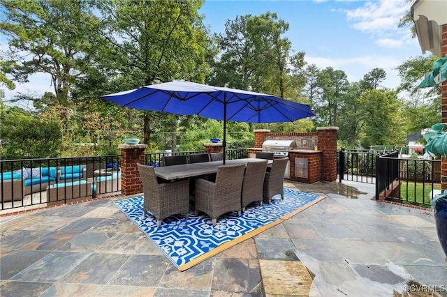 view of patio with exterior kitchen, outdoor dining space, fence, and area for grilling