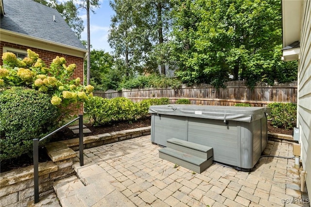 view of patio with fence and a hot tub