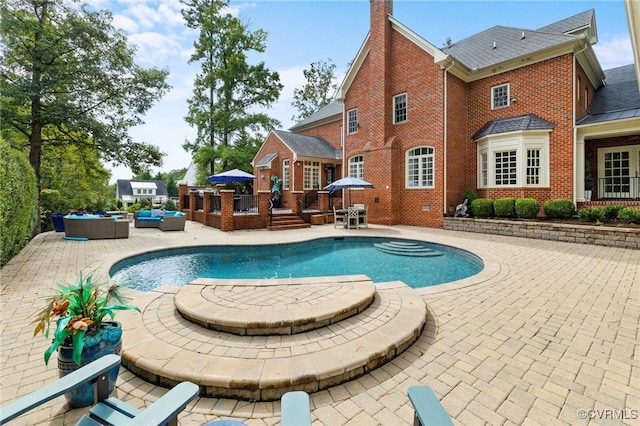 pool with a patio, an outdoor living space, and a wooden deck