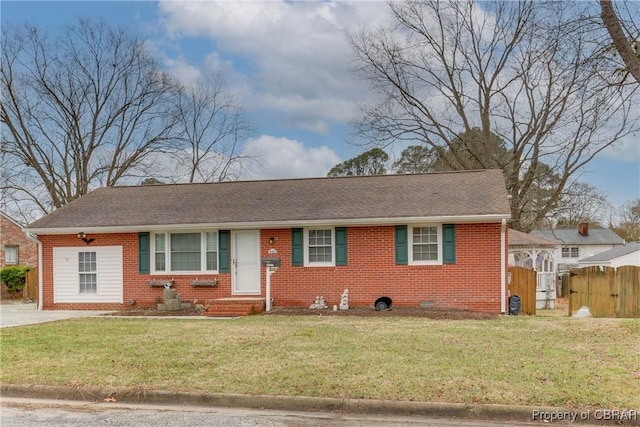 view of front of house with a shingled roof, fence, a front lawn, and brick siding