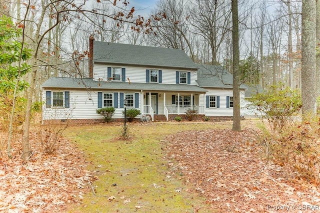 view of front facade featuring crawl space, covered porch, a chimney, and a front yard