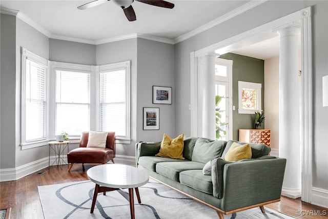 living area with ceiling fan, plenty of natural light, wood finished floors, and ornate columns