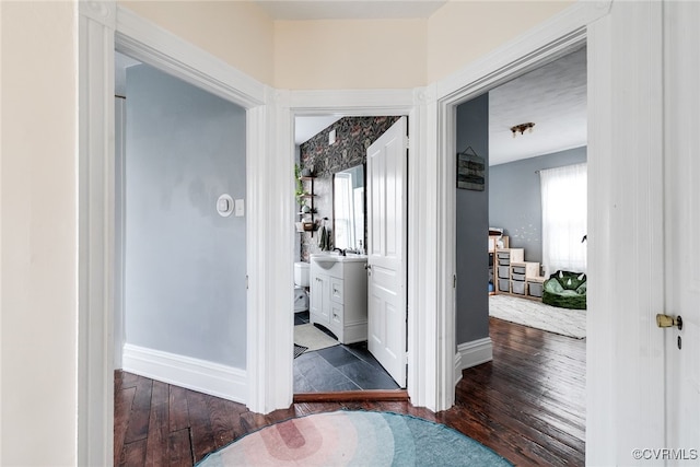 corridor with baseboards and hardwood / wood-style floors