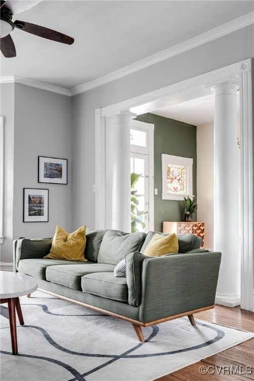 living room with crown molding, ceiling fan, and wood finished floors