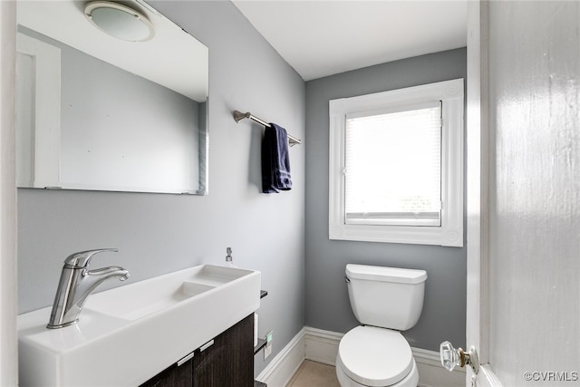 bathroom with vanity, toilet, and baseboards