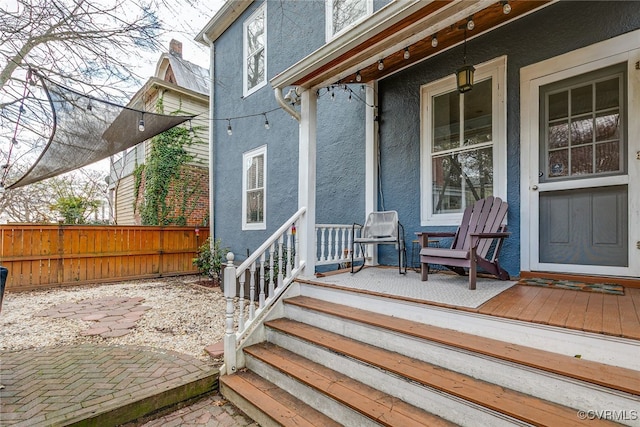 wooden deck featuring a porch and fence