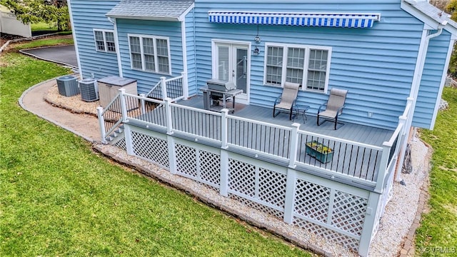 back of house with a deck, central AC unit, a lawn, and roof with shingles