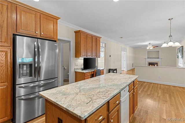 kitchen featuring brown cabinets, a warm lit fireplace, and stainless steel refrigerator with ice dispenser