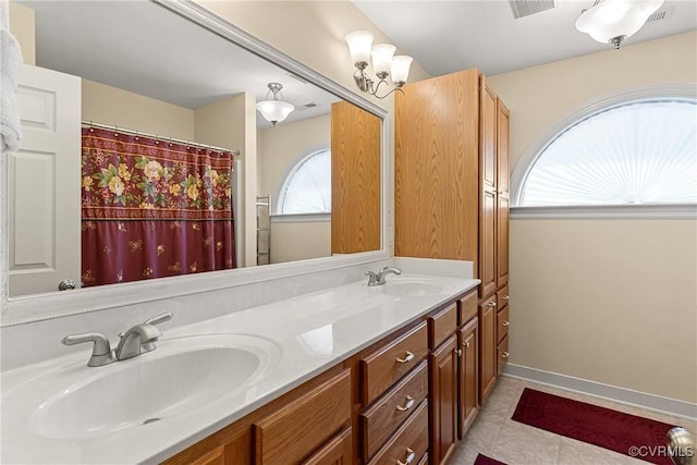 full bath with double vanity, tile patterned flooring, baseboards, and a sink