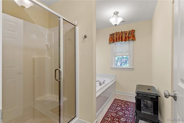 full bathroom featuring heating unit, a shower stall, tile patterned flooring, baseboards, and a bath