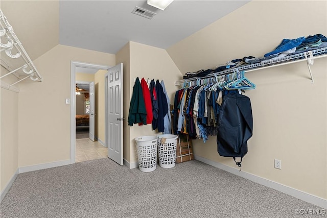 spacious closet featuring vaulted ceiling, visible vents, and carpet floors