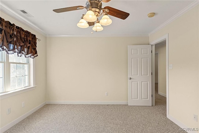 empty room featuring visible vents, light colored carpet, crown molding, and baseboards