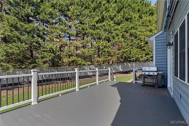 wooden deck with grilling area and a fenced backyard