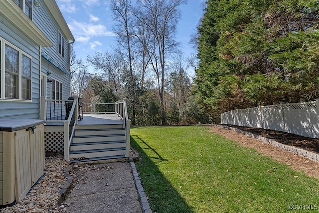 view of yard with a wooden deck, stairs, and fence