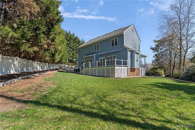 rear view of house featuring a yard, a deck, and fence