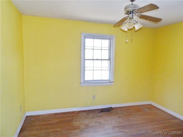 spare room featuring ceiling fan, wood finished floors, and baseboards