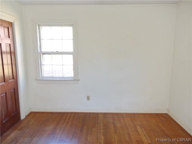 empty room featuring baseboards and wood finished floors