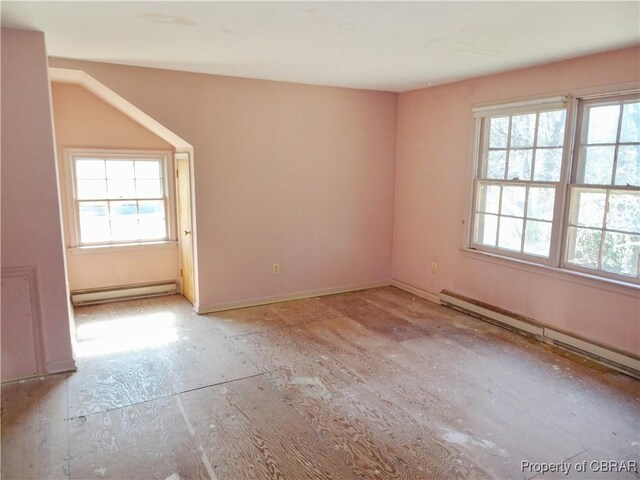 unfurnished room featuring a baseboard radiator, plenty of natural light, and a baseboard heating unit