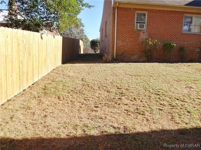 view of property exterior featuring a yard, fence, cooling unit, and brick siding