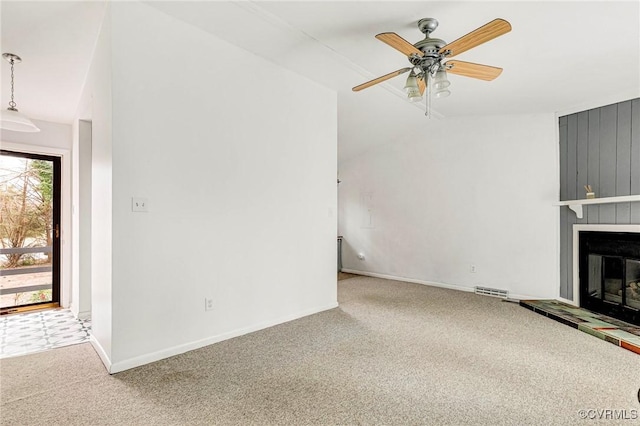 unfurnished living room featuring visible vents, baseboards, carpet floors, a fireplace, and ceiling fan