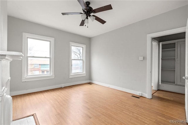 unfurnished living room with ceiling fan, light wood-style flooring, visible vents, and baseboards