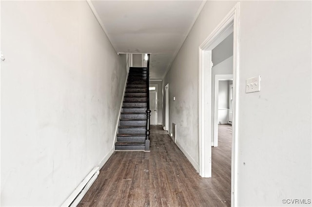 stairs with crown molding and wood finished floors