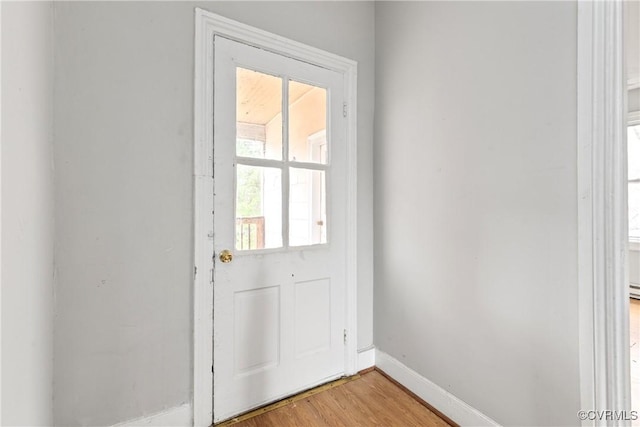 doorway to outside with light wood-type flooring and baseboards