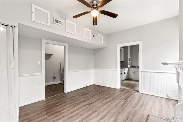 empty room featuring wood finished floors and wainscoting