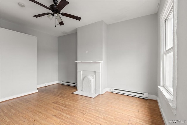 unfurnished living room with baseboard heating, a fireplace, and light wood-style floors