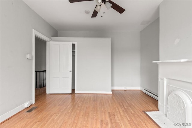 unfurnished living room featuring light wood-type flooring, a baseboard radiator, visible vents, and baseboards