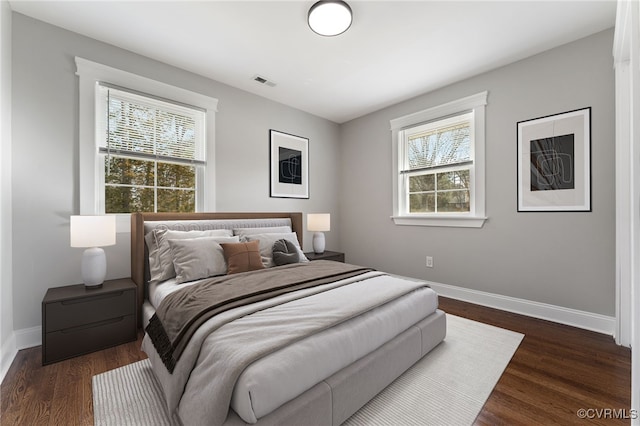 bedroom featuring dark wood-style floors, visible vents, and baseboards