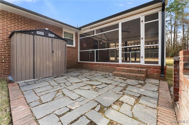 view of patio / terrace featuring a storage shed, an outdoor structure, and a sunroom