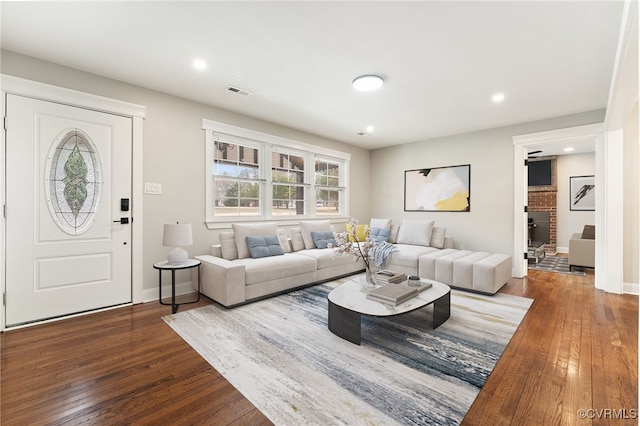 living room with dark wood-style floors, baseboards, visible vents, and recessed lighting