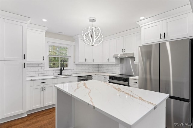 kitchen with white cabinets, decorative backsplash, stainless steel appliances, under cabinet range hood, and a sink