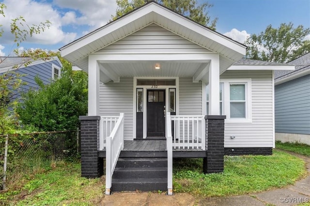 view of front of house featuring covered porch and fence