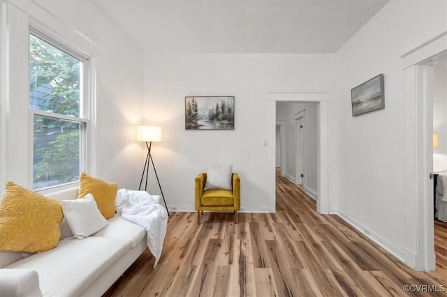 living area featuring light wood-style flooring and baseboards