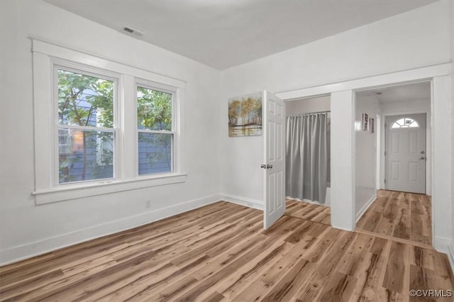 interior space with baseboards, visible vents, and light wood-style floors