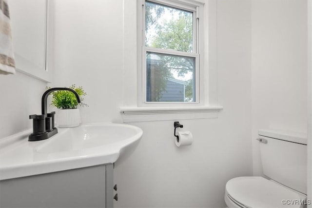 half bathroom with vanity and toilet