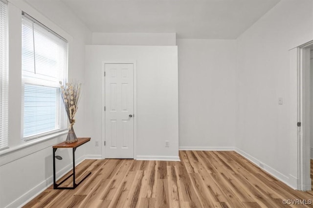 empty room with light wood-style flooring and baseboards