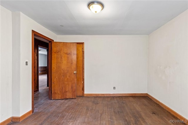 unfurnished room featuring hardwood / wood-style floors and baseboards